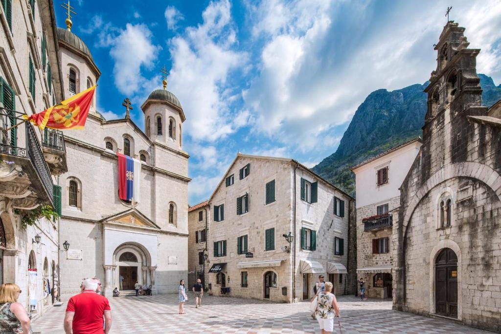 a group of people walking through a street with buildings at CENTRUM HOSTEL in Kotor