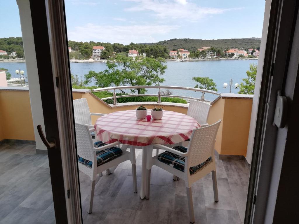 a table and chairs on a balcony with a view of the water at Apartments Marijan - sea view in Veli Rat
