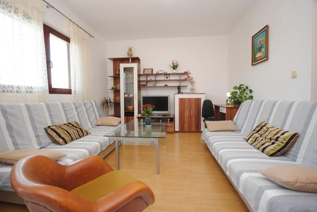 a living room with two couches and a glass table at Apartments Ezgety - 330m from beach in Kaštela