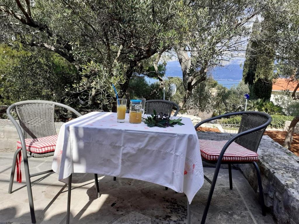 una mesa con dos sillas y dos vasos de zumo de naranja en Holiday home Olive- 150m from sea, en Splitska