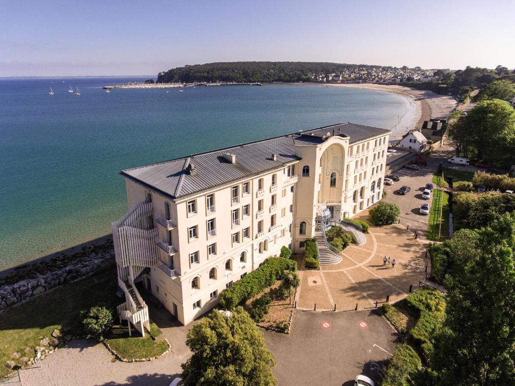 - une vue aérienne sur un bâtiment à côté d'une plage dans l'établissement Hôtel Morgat Le Grand Hôtel De La Mer, à Crozon