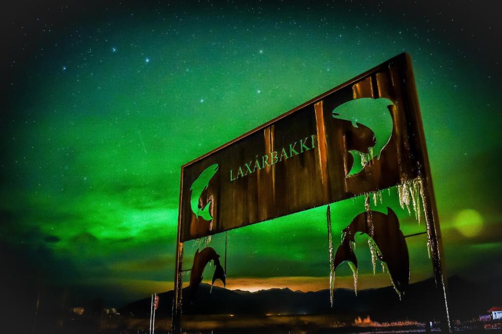 a sign with the northern lights in the sky at Hotel Laxarbakki in Leirá