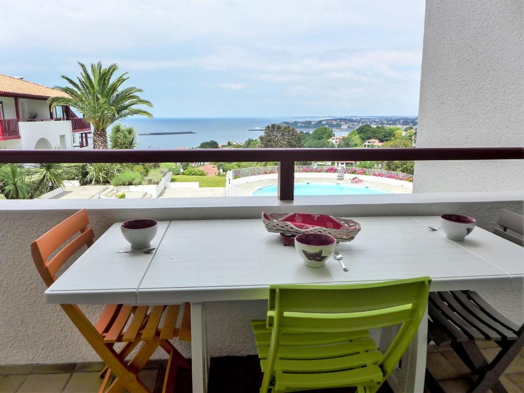 una mesa y sillas en un balcón con vistas al océano en Apartment Les Hauts de Bordagain-3 by Interhome, en Socoa