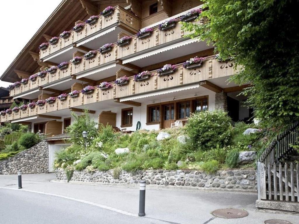a building with flowers on the side of it at Apartment Drive by Interhome in Gstaad