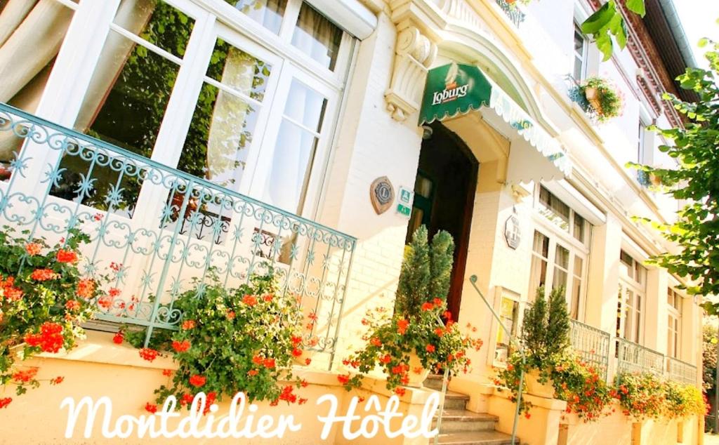 a building with flowers in front of a balcony at Montdidier Hôtel in Montdidier