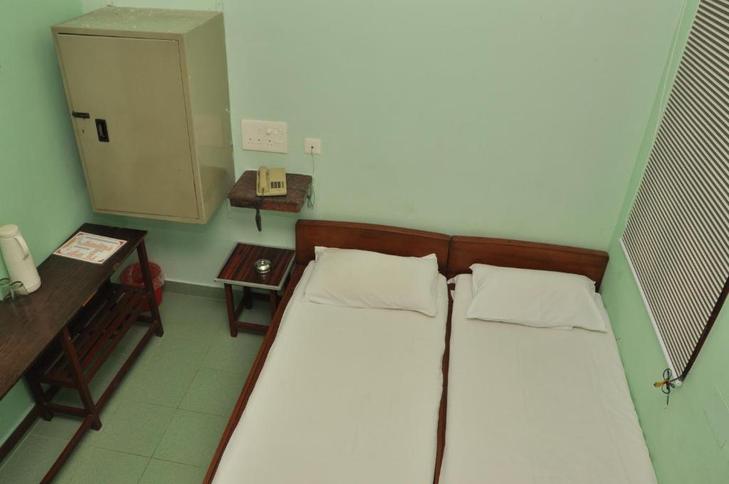 a small room with a bed and a telephone at VALLI HOTEL in Thanjāvūr