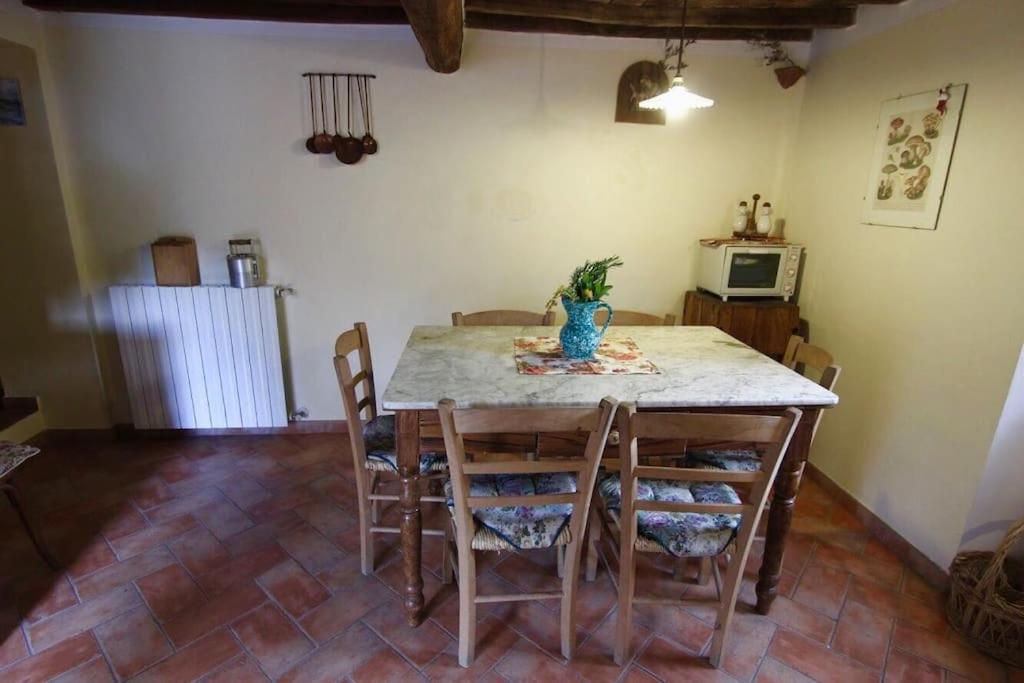 une cuisine avec une table et des chaises ainsi qu'une table sidx sidx sidx dans l'établissement I Poderi - Lovely Country House in Maremma, à Caldana