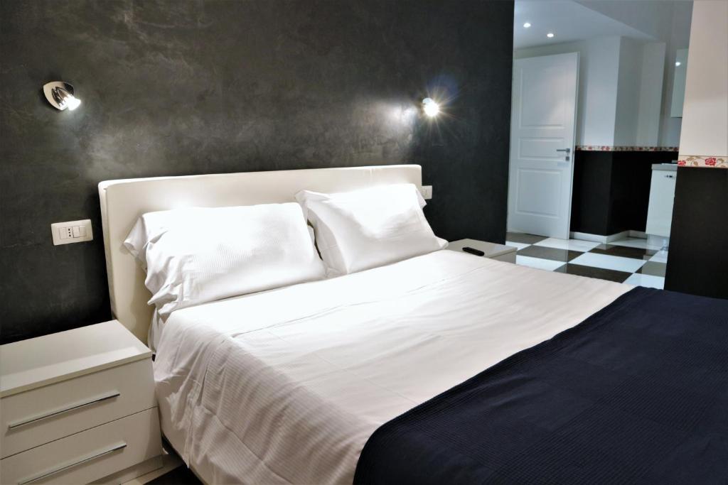 1 dormitorio con cama blanca y pared negra en Luxury Vatican Rooms en Roma