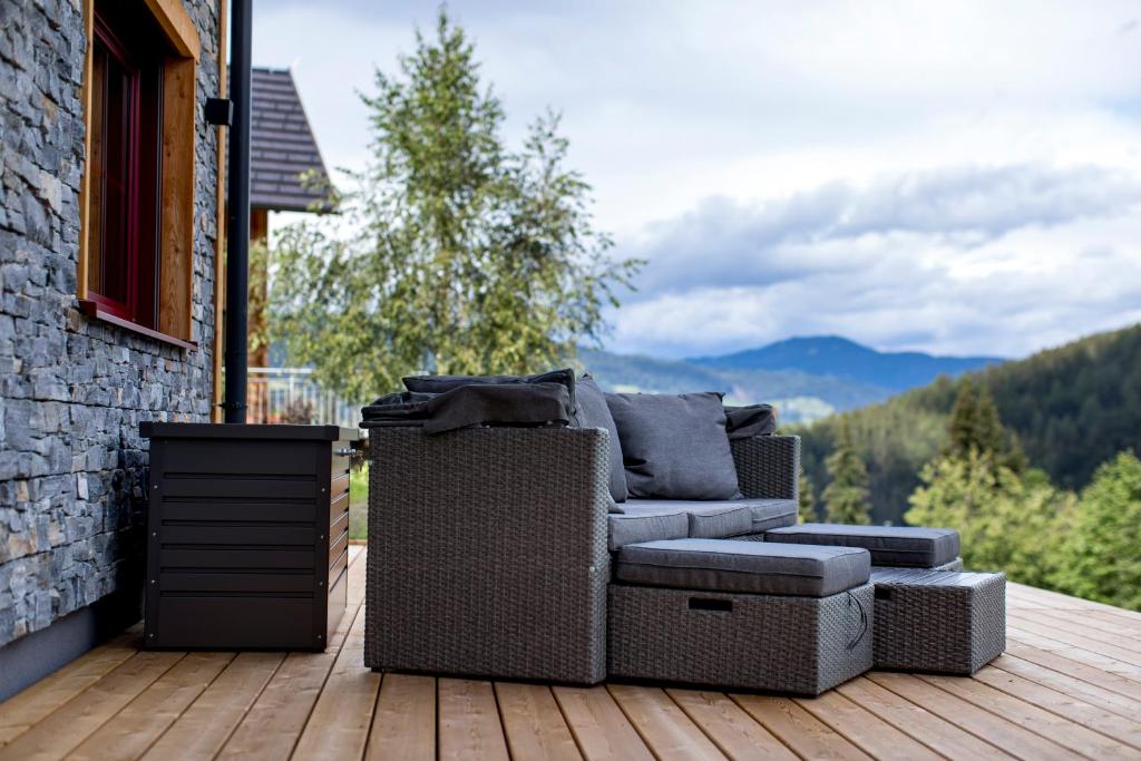 a chair and ottoman sitting on a deck at Konradgut 11 - Ruhe und Aussicht auf 1140m in Sankt Lorenzen ob Murau