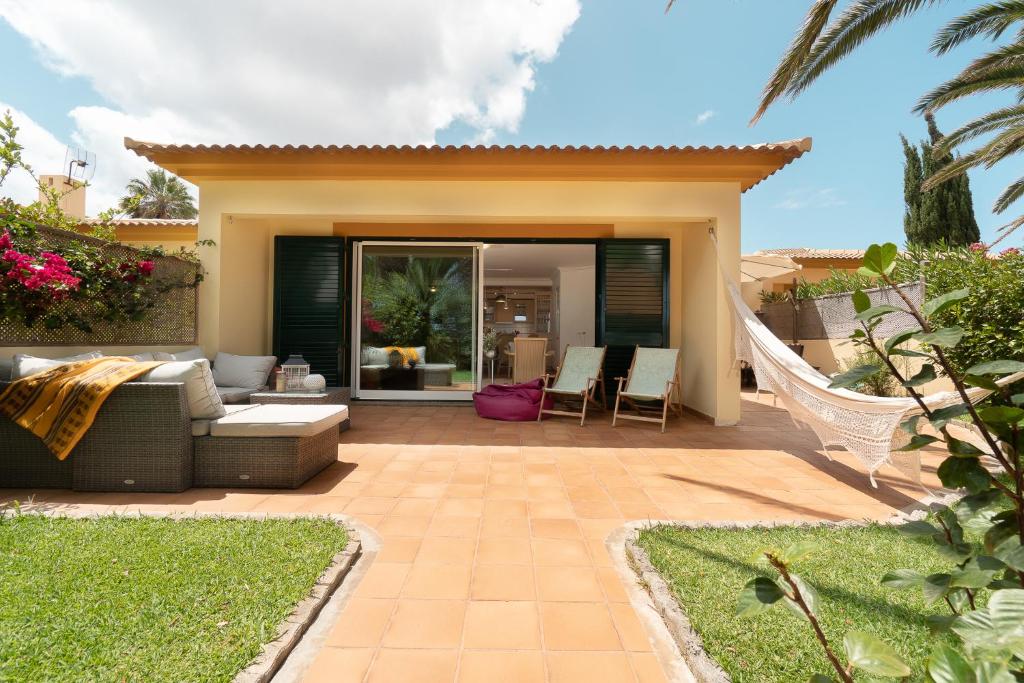 eine Terrasse mit Sofa und Stühlen vor einem Haus in der Unterkunft CASA NA PRAIA in Vila Baleira