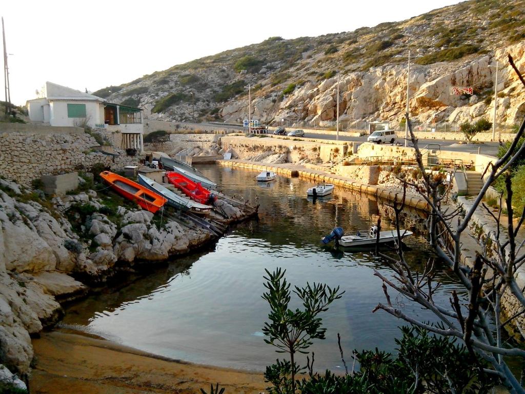 a group of boats in a body of water at Cabanon du Pêcheur, Parc National des Calanques in Marseille