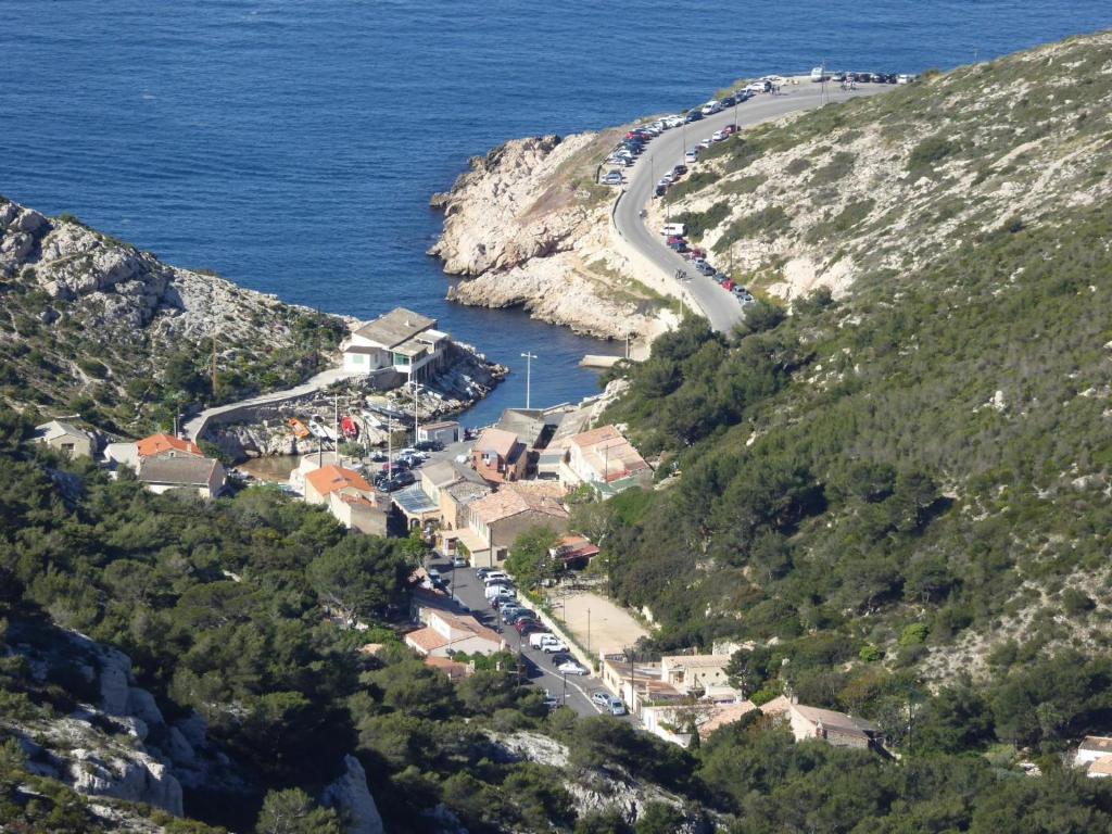 a town on a hill next to the ocean at Cabanon du Pêcheur, Parc National des Calanques in Marseille