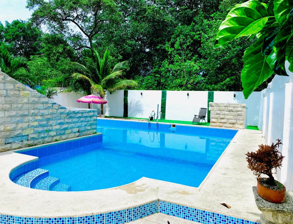 a swimming pool in a backyard with a blue at Hotel Oro Blanco in Atacames