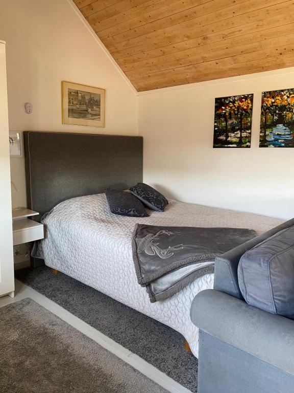 ein kleines Schlafzimmer mit einem Bett und einem Sofa in der Unterkunft Stubbhuggets Lillstuga in Trosa