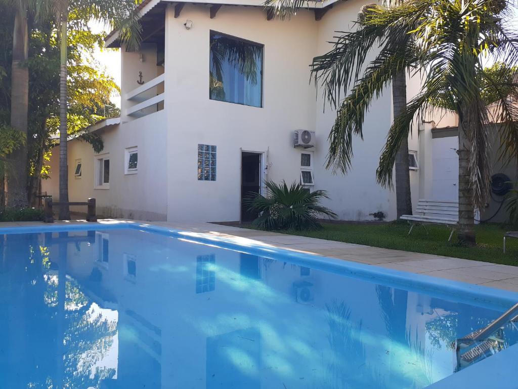 une maison avec une piscine en face d'une maison dans l'établissement CASA DE PRAIA COM PISCINA e AREA GOURMET, à Caraguatatuba