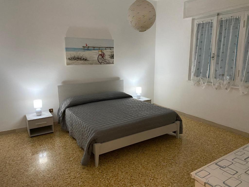 a bedroom with a bed and two night stands at APPARTAMENTO VENERE in Cecina