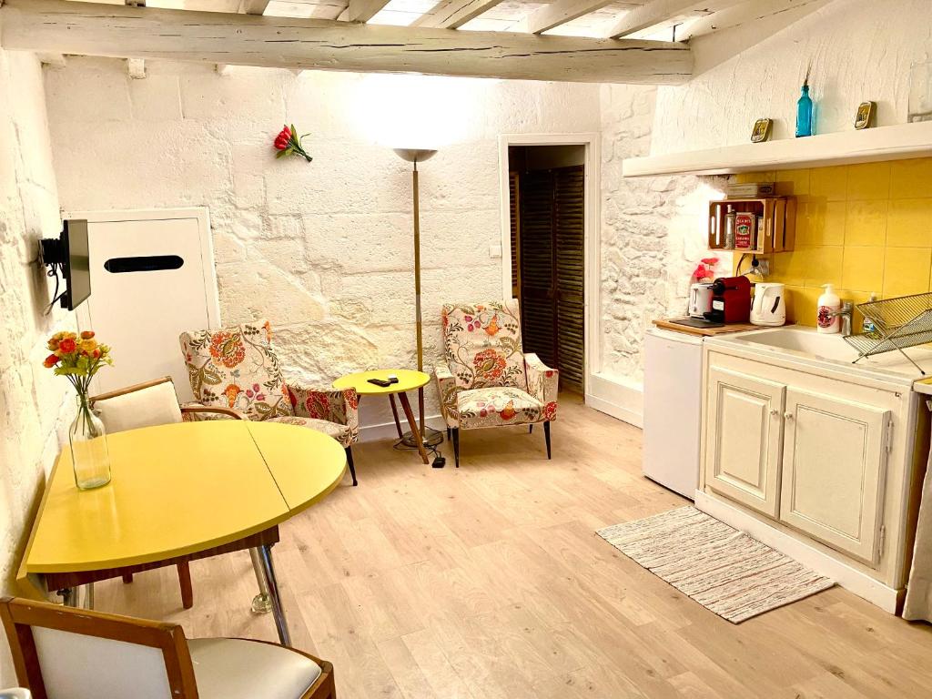 a kitchen with a table and chairs and a yellow table at La maison de Fanny in Arles