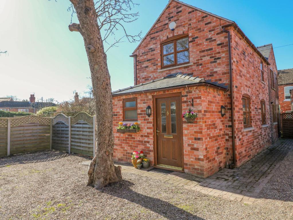 a brick building with a door next to a tree at The Stable in Lincoln