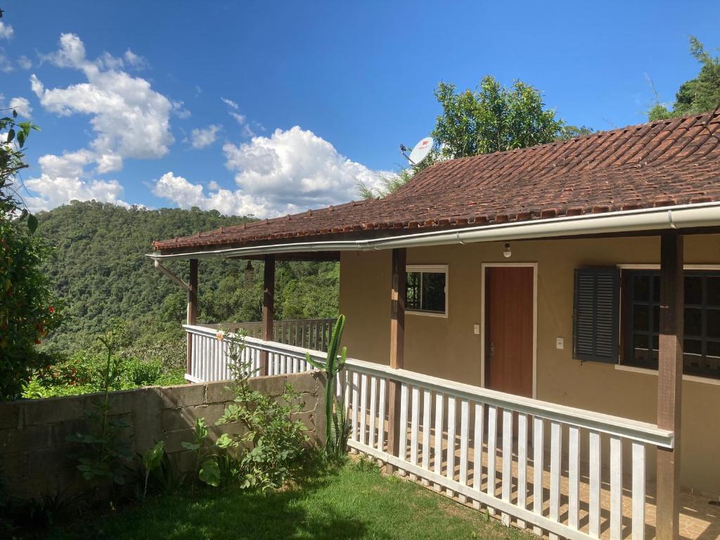 a house with a white fence and a porch at Casa Vista do Vale in Visconde De Maua