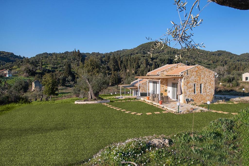 une maison en pierre avec une grande cour dans l'établissement Ktima Arillas, à Arillas