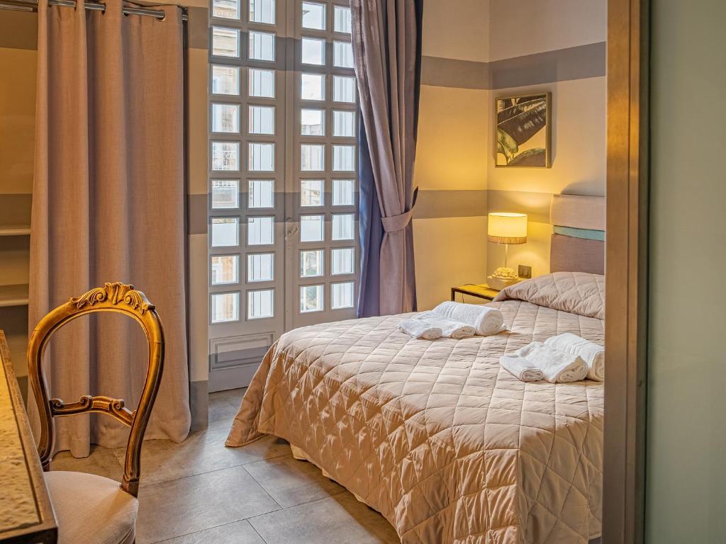 sypialnia z łóżkiem i oknem w obiekcie Design 4 Rooms w Syrakuzach