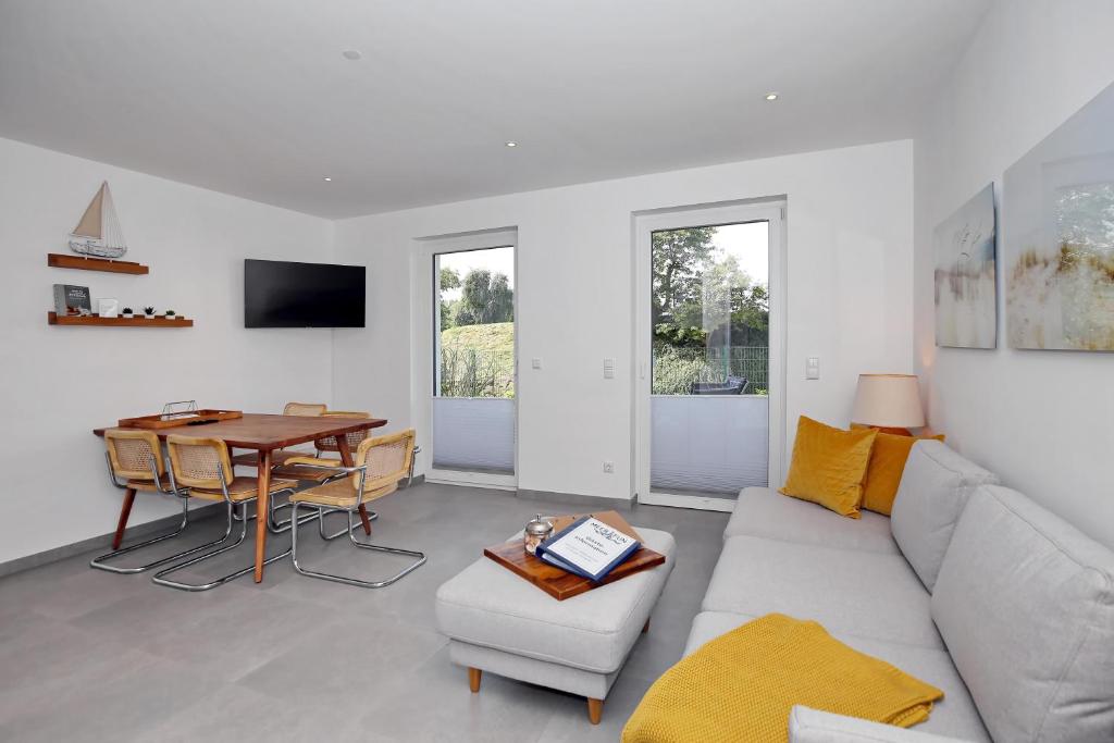 ein Wohnzimmer mit einem Sofa und einem Tisch in der Unterkunft Strandresidenz Dünenperle Wohnung 9 in Kühlungsborn
