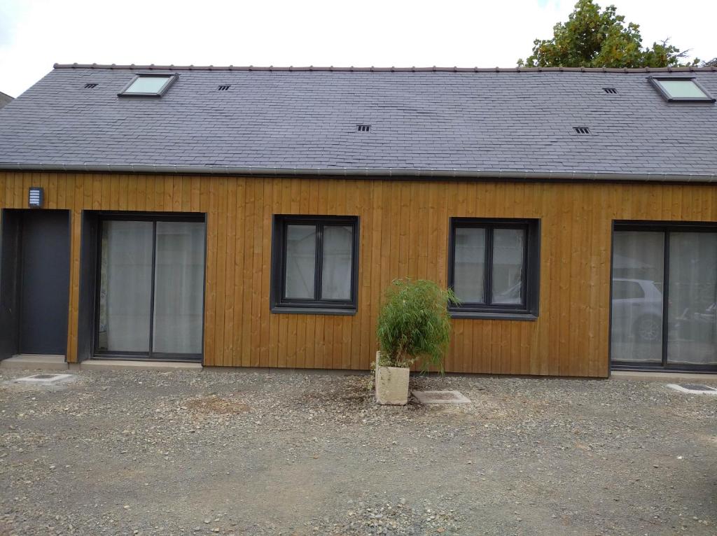 una casa con ventanas y una planta frente a ella en Les petits gites en Ernée