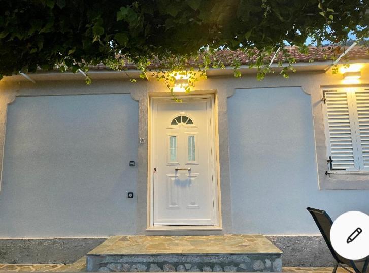 a house with a white door and two windows at Dina’s house 2 in Argostoli