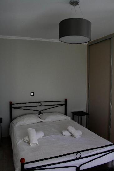 sypialnia z łóżkiem z białą pościelą i poduszkami w obiekcie Dina’s house 2 w mieście Argostoli