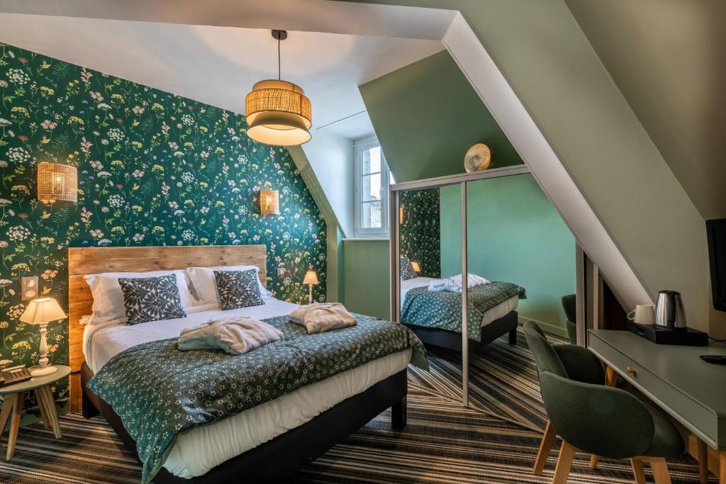 1 dormitorio con 2 camas y paredes verdes en Le Bailliage Hôtel & Spa, en Salers