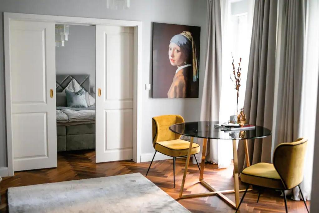 - un salon avec une table, des chaises et un lit dans l'établissement Exclusive calm and designer flat - Yael's apartments - Charlottenburg by Arbio, à Berlin