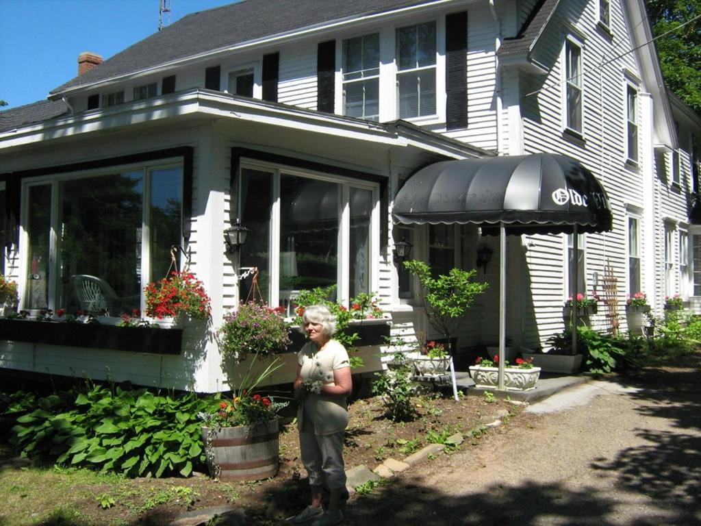 a woman standing in front of a house at The Olde Village Inn in Centreville