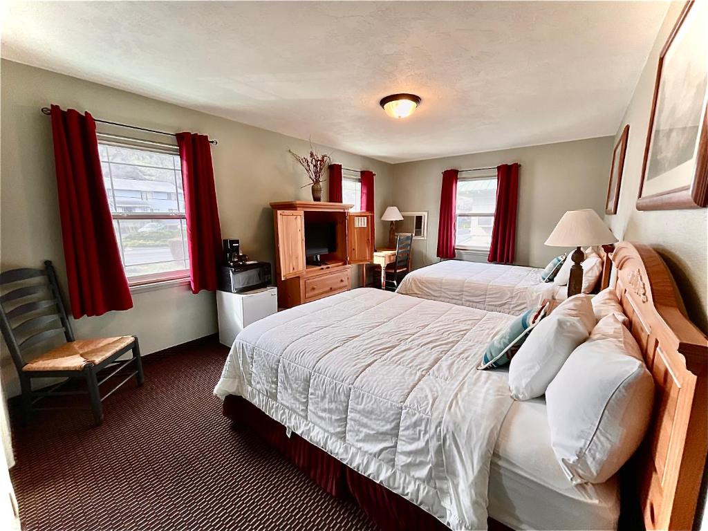 a bedroom with two beds with red curtains at Rugged Country Lodge in Pendleton