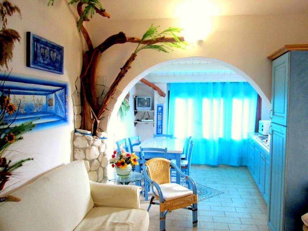a living room with a couch and a table at Sardinia Yellow House in Solanas