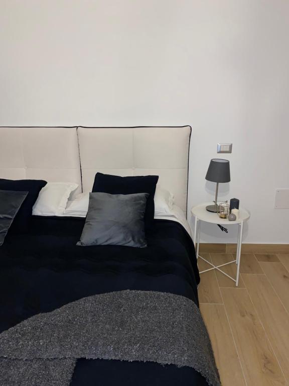 sypialnia z czarno-białym łóżkiem i stołem w obiekcie Pvteoli Suite w mieście Pozzuoli