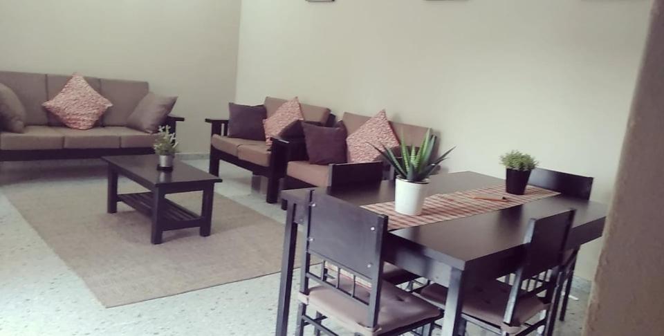 a living room with a table and a couch at Ibex Hill apartment in Lusaka