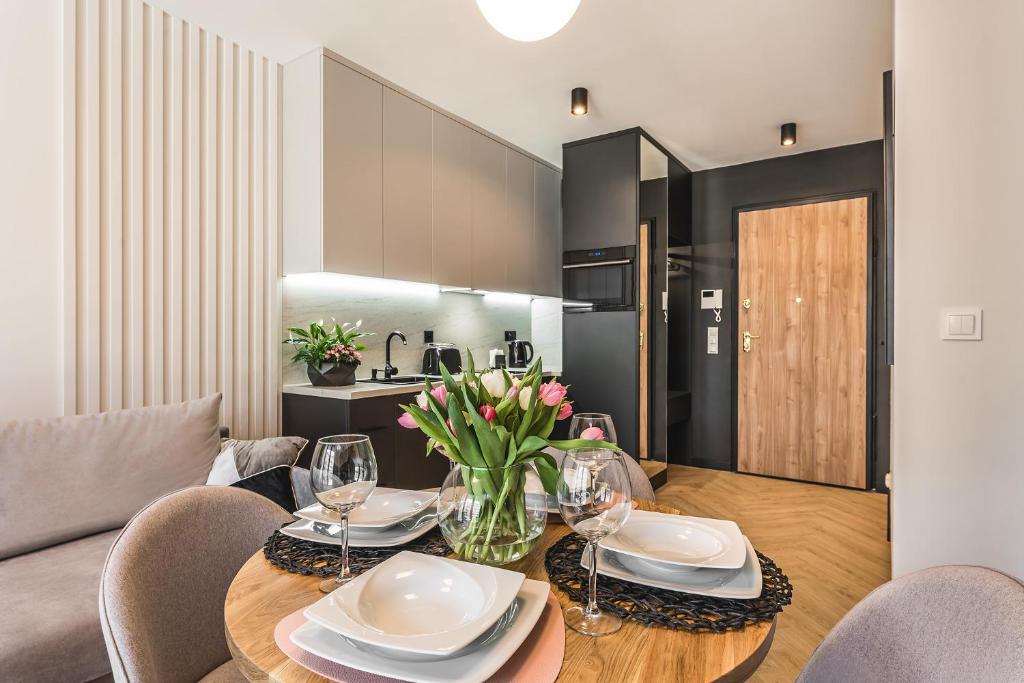 a dining room with a table and chairs and a kitchen at Apartament Moje Miasto in Gdynia