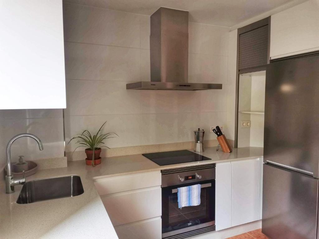 a kitchen with a sink and a stove top oven at APTO. SANXURXO in Camariñas