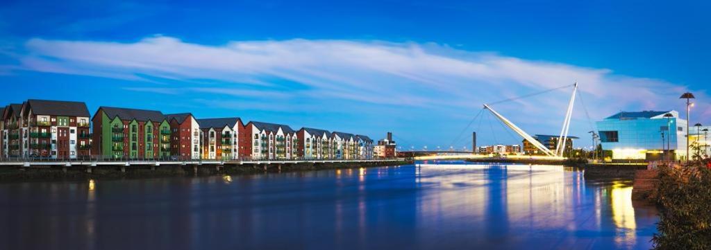 Blick auf einen Fluss mit Gebäuden und einer Brücke in der Unterkunft Luxury 2 Bedroom waterfront apartment with balcony in Newport