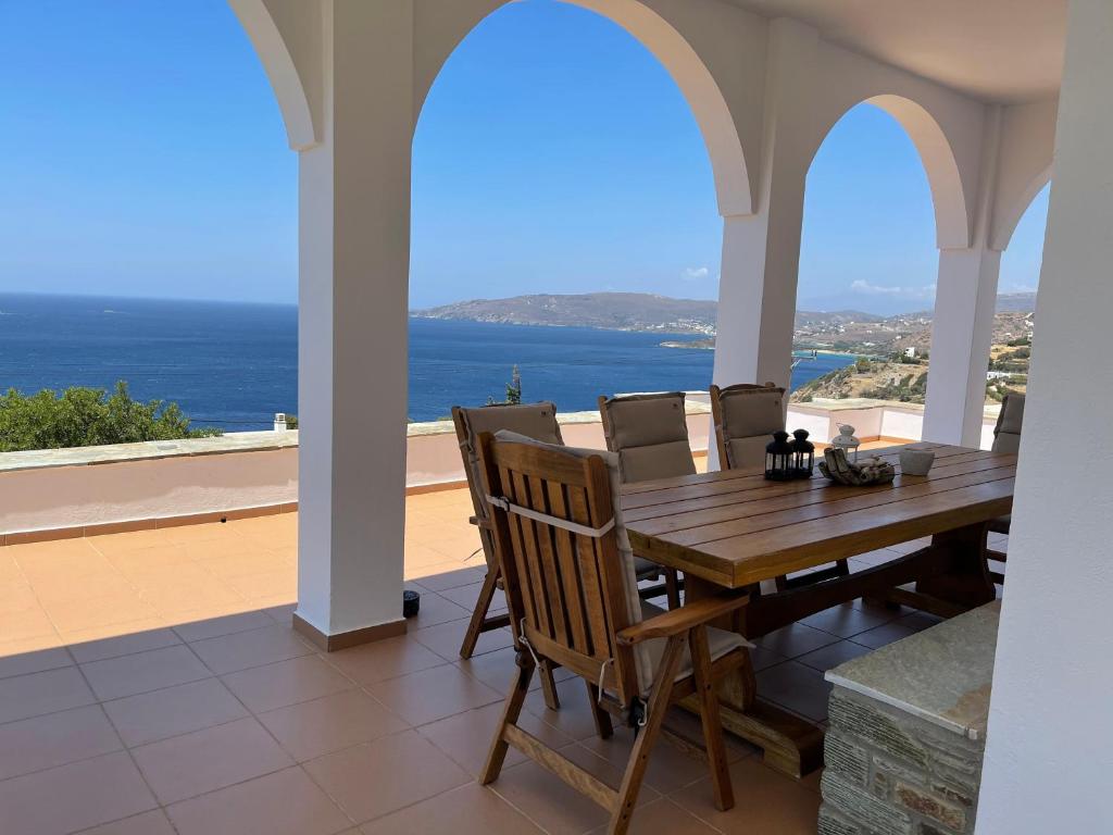 uma sala de jantar com uma mesa e vista para o oceano em villa hena em Batsi