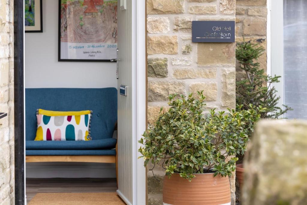 a porch with a blue bench and a pillow at Old Hall Croft Barn in Skipton