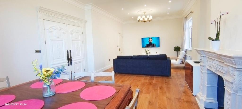een woonkamer met een tafel en een bank bij Marigold Villa in Harrow