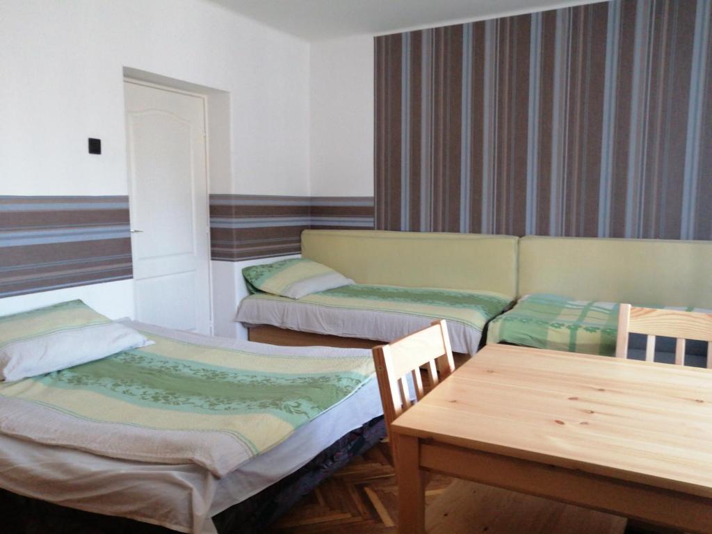 ミシュコルツにあるBelvárosi Vendégházのベッド2台、ソファ、テーブルが備わる客室です。
