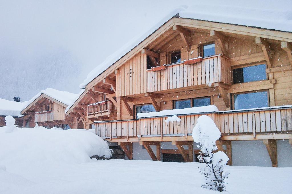 a large wooden house with snow on the ground at Les Chalets des Liarets in Chamonix