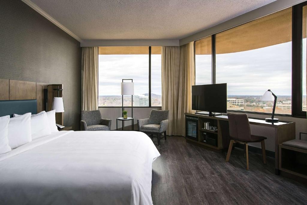 a hotel room with a bed and a television at Sonesta Nashville Airport in Nashville