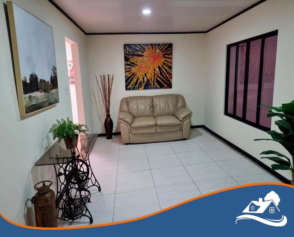 a living room with a couch and a painting on the wall at Casa Colima in Isla de Tibás