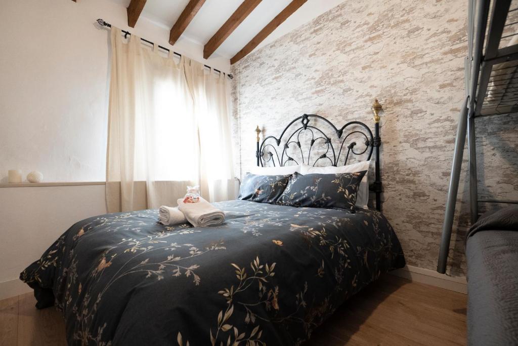 sypialnia z łóżkiem z czarną narzutą i oknem w obiekcie Casa rural La bodega w Alicante