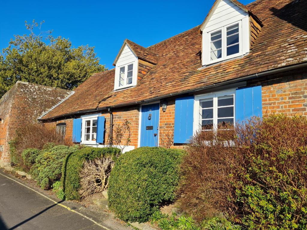 溫徹斯特的住宿－Beggar's Lane Cottage，一座砖房,上面有蓝色的油漆
