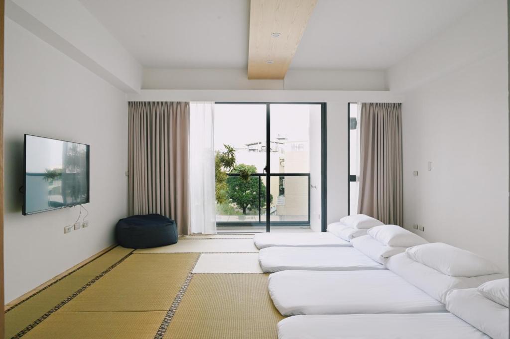 una habitación con una fila de sofás blancos en 台南安平包棟民宿 - 定言豪宅館, en Anping