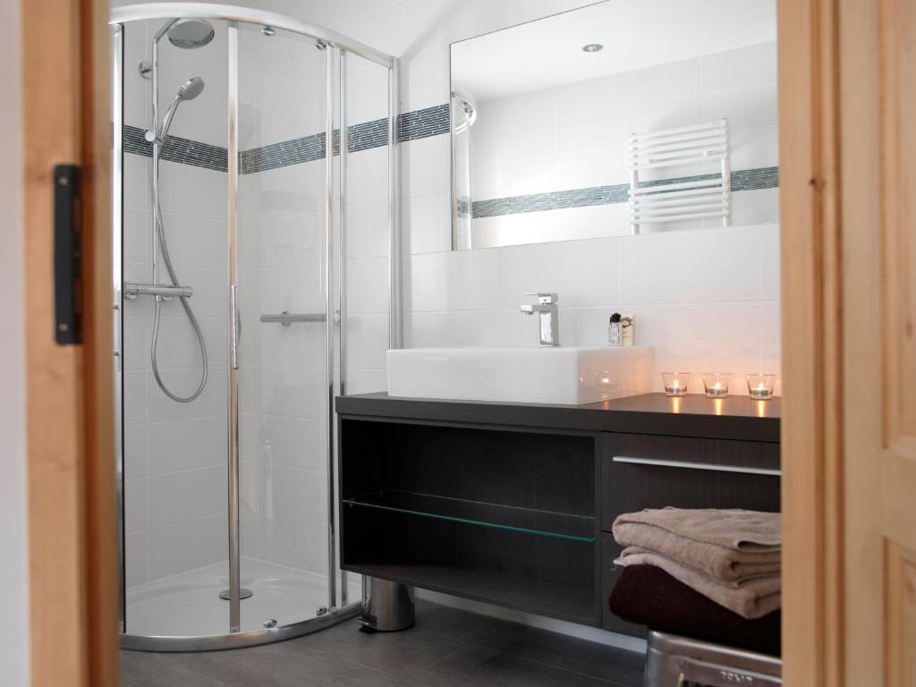a bathroom with a glass shower and a sink at Les Chalets des Liarets in Chamonix